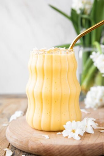 Healthy Mango Banana Smoothie on a wood board.