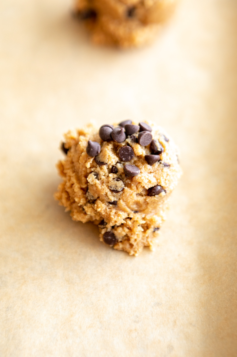 Vegan peanut butter cookie dough scooped on to a baking sheet.