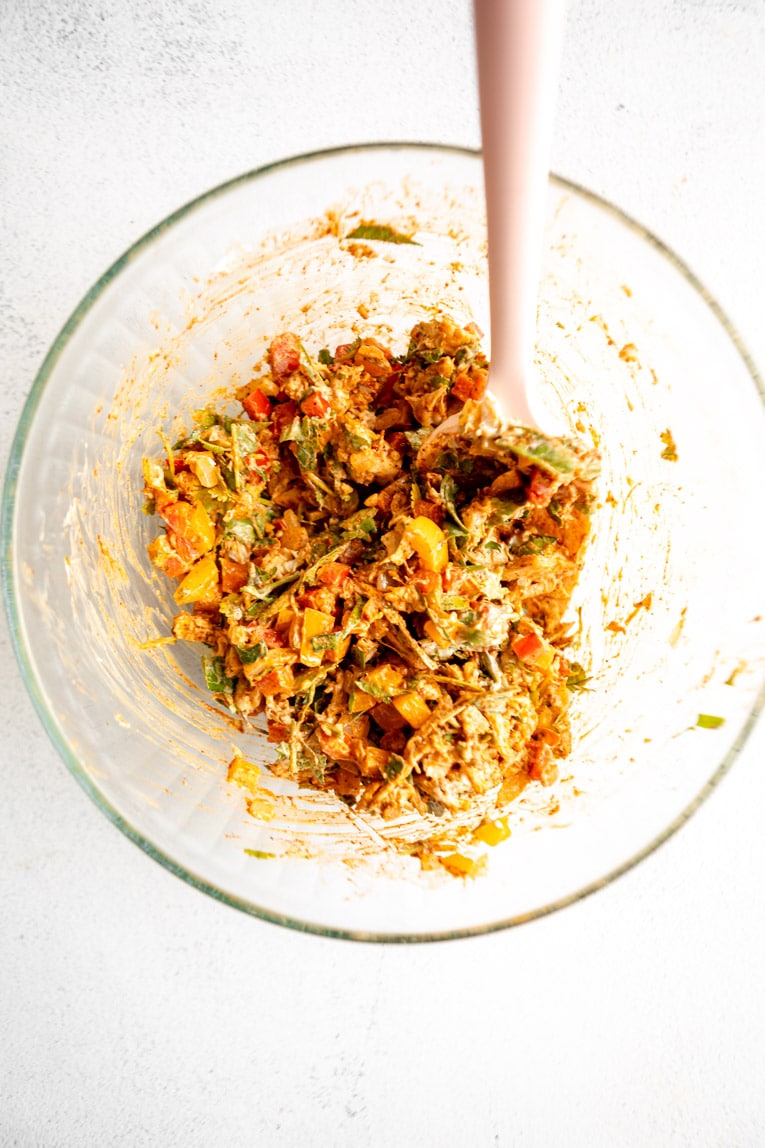 Chicken empanadas filling being mixed in a bowl.