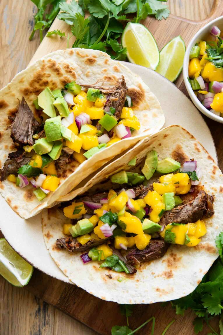 steak tacos on a plate with mango jalapeño salsa.