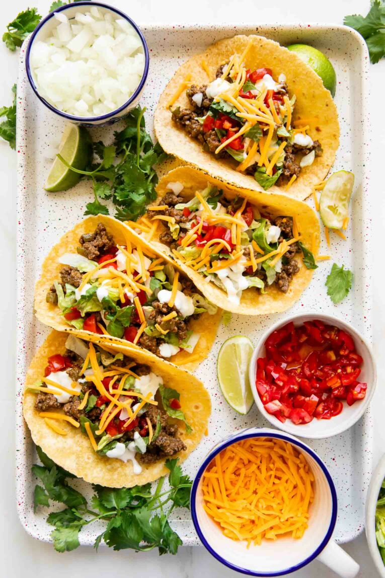 Top photo of Ground Beef Tacos with toppings on a sheet pan.