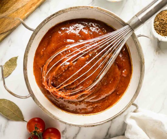Homemade BBQ Sauce Recipe in a bowl with a whisk and ingredients.
