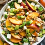Peach Mozzarella Salad recipe on a plate with ingredients around it.