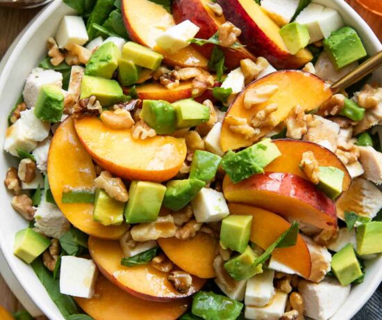 Peach Mozzarella Salad recipe on a plate with ingredients around it.