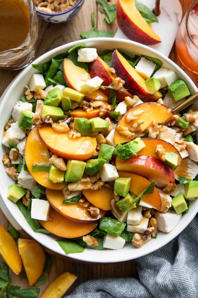 Peach Mozzarella Salad recipe on a plate with ingredients around it.