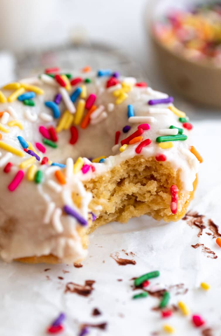 Bite taken out of a glazed Protein Donut with sprinkles.