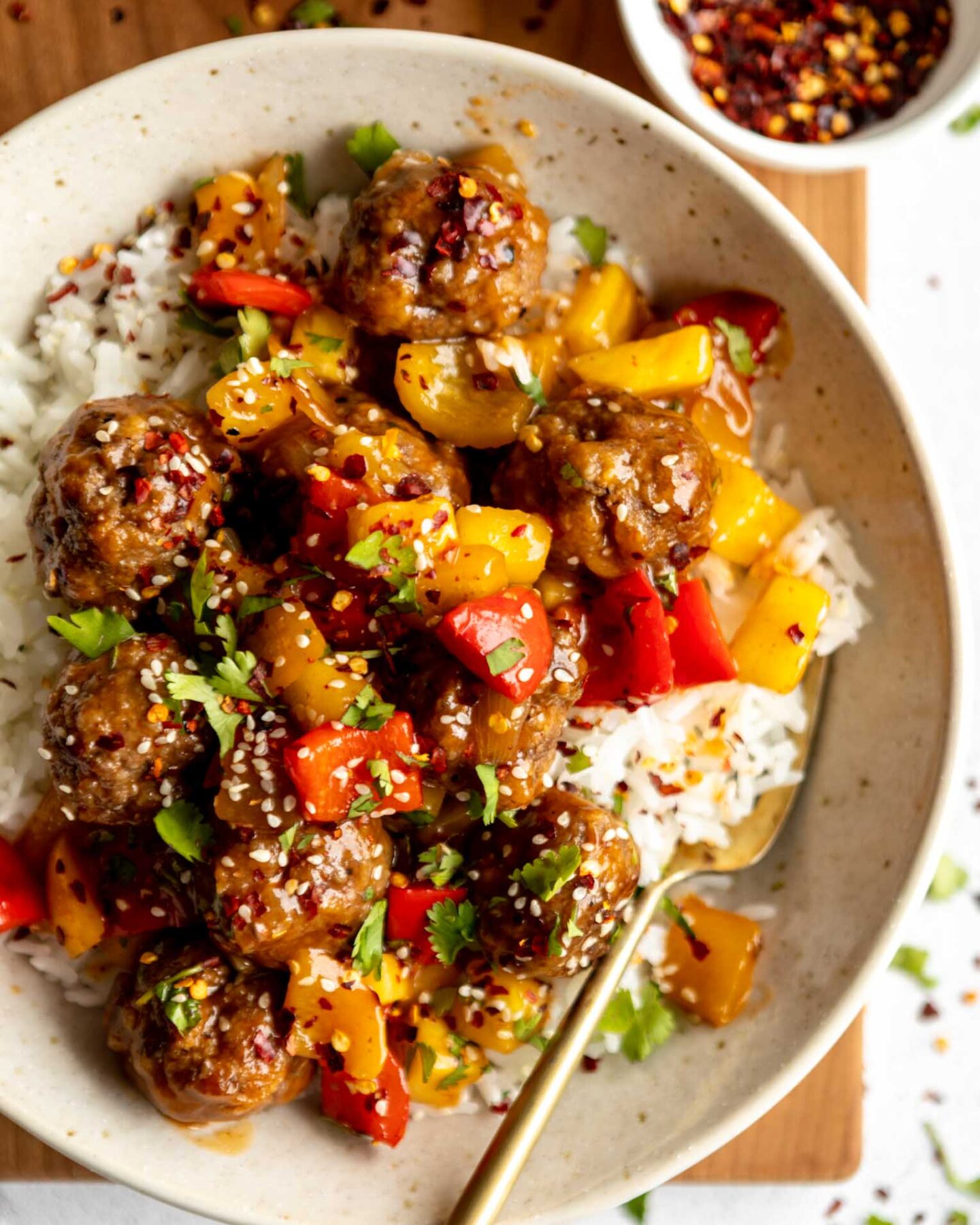 Sweet & sour meatballs with stir fry in a bowl.
