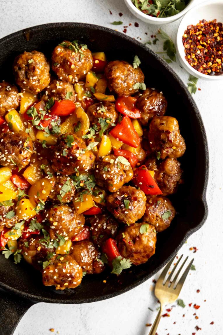 Sweet & sour meatballs in a sauce in a skillet.
