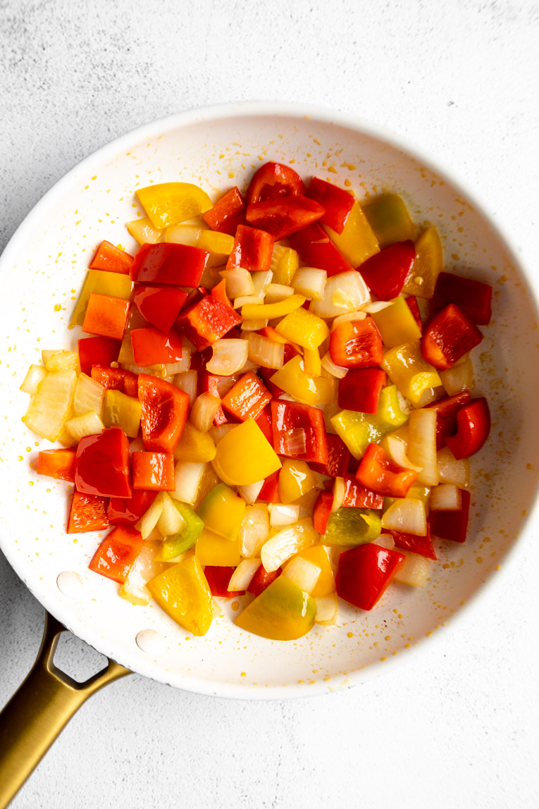 Fresh chopped veggies being cooked in a skillet.