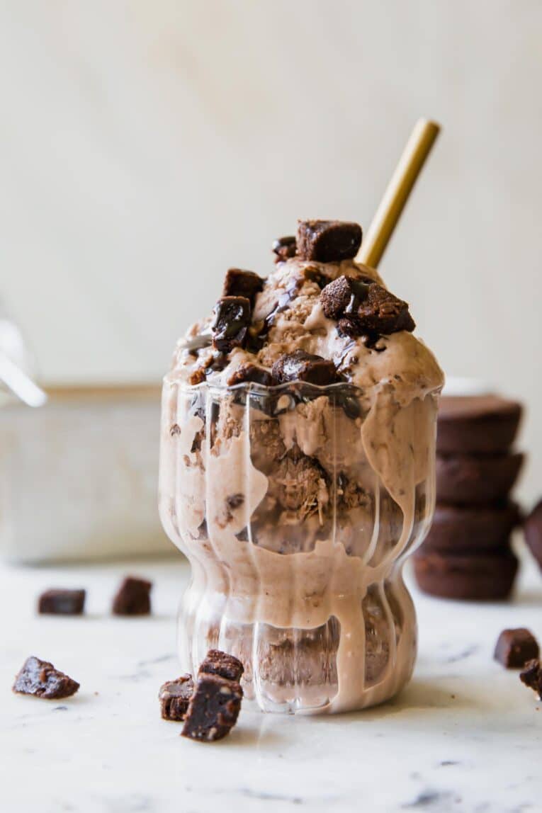 Protein brownie ice cream with brownies and chocolate syrup.