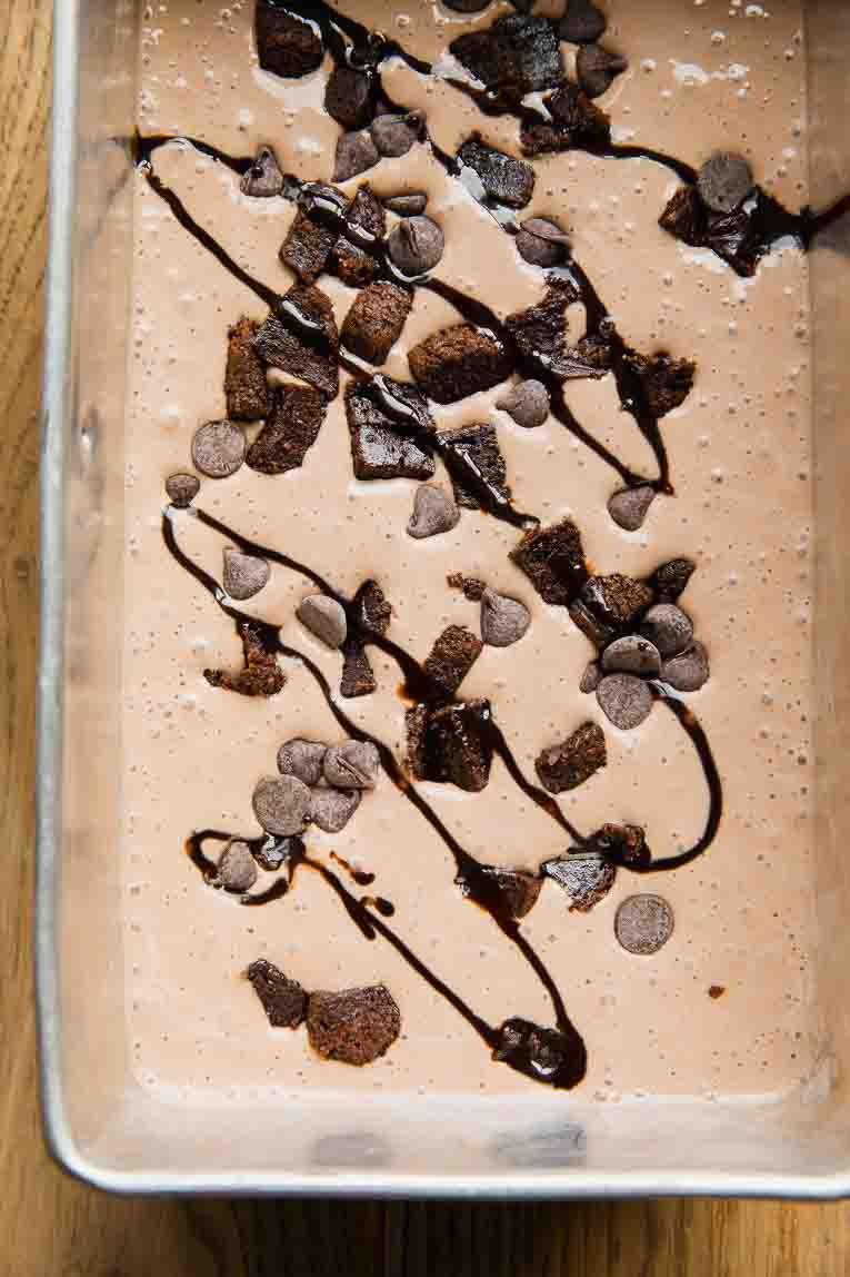 Brownie Ice Cream batter in a loaf pan with toppings.