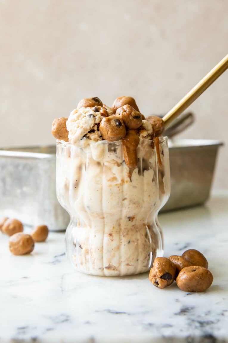 Cookie Dough Ice Cream recipe with protein bites and chocolate chips in a glass with a spoon.