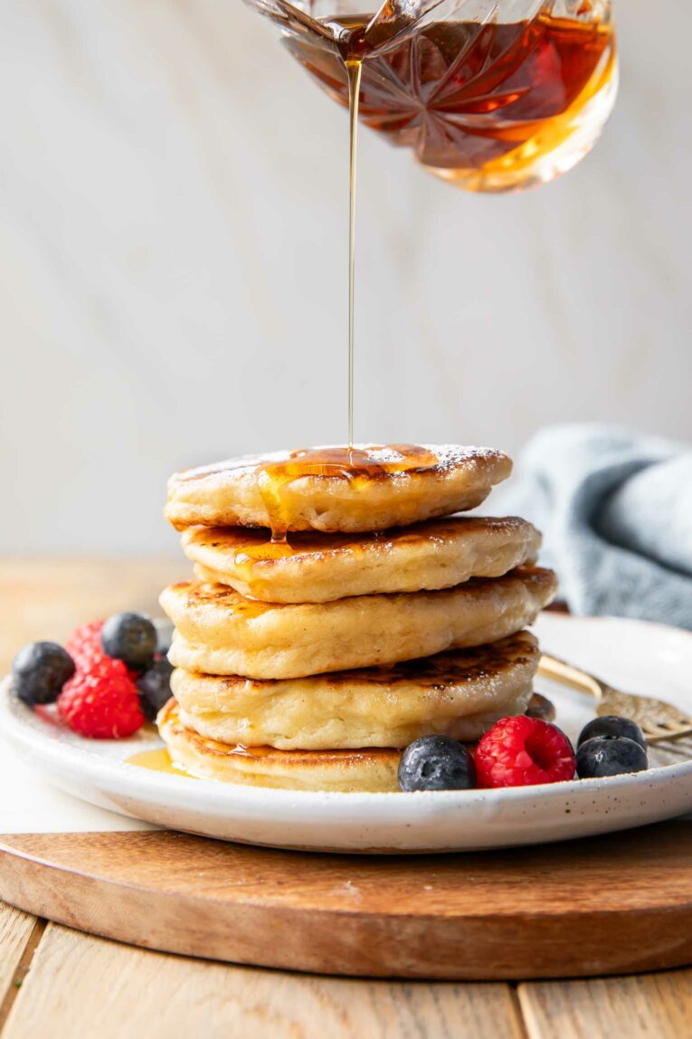 Syrup pouring over stack of Cottage Cheese Pancakes.
