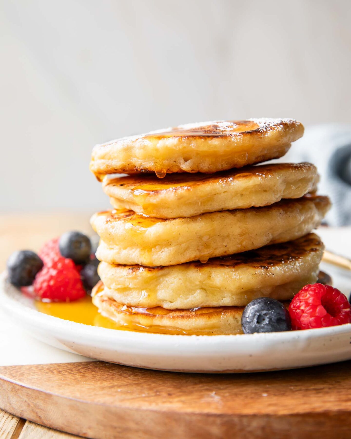 Cottage Cheese Pancakes recipe stacked on a plate with syrup.