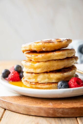 Cottage Cheese Pancakes recipe stacked on a plate with syrup.