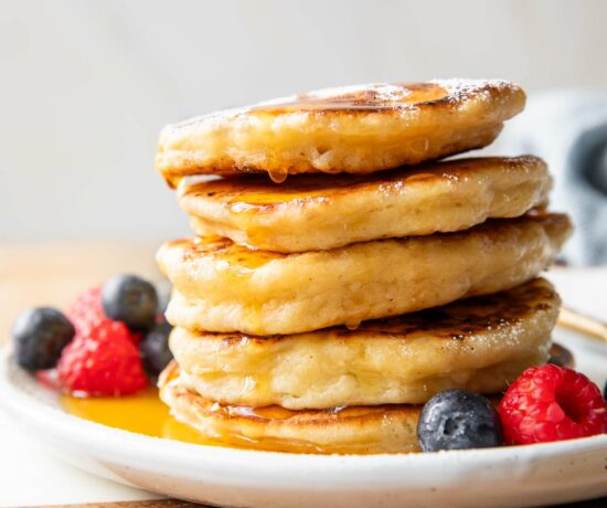 Cottage Cheese Pancakes recipe stacked on a plate with syrup.