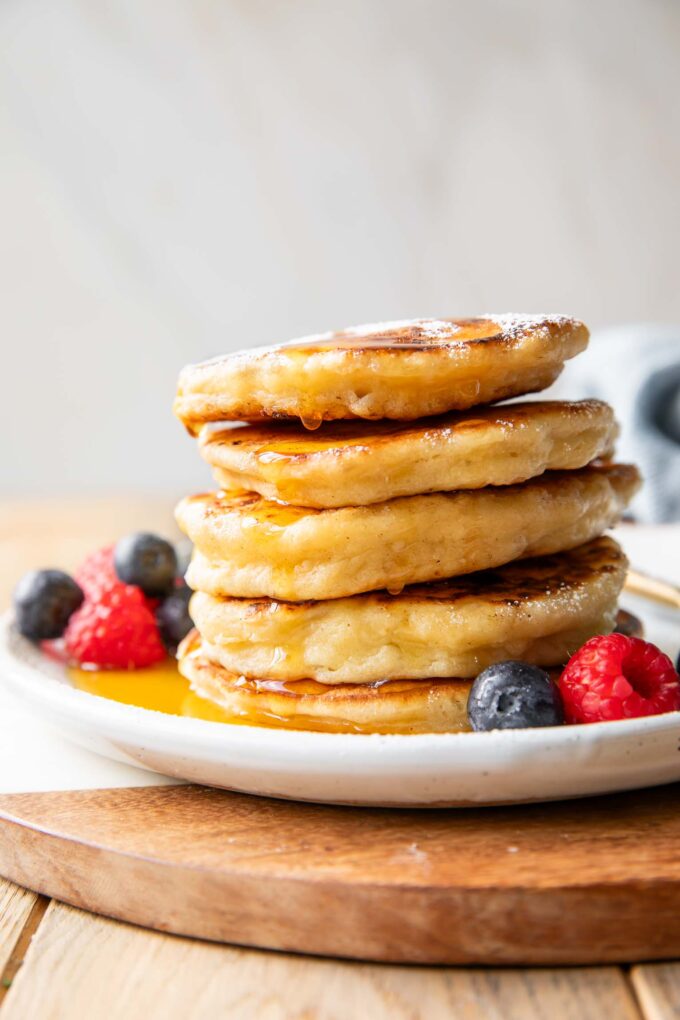 Cottage Cheese Pancakes recipe stacked on a plate with syrup.