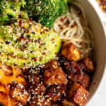 Asian fried tofu with avocado, veggies, and noodles.