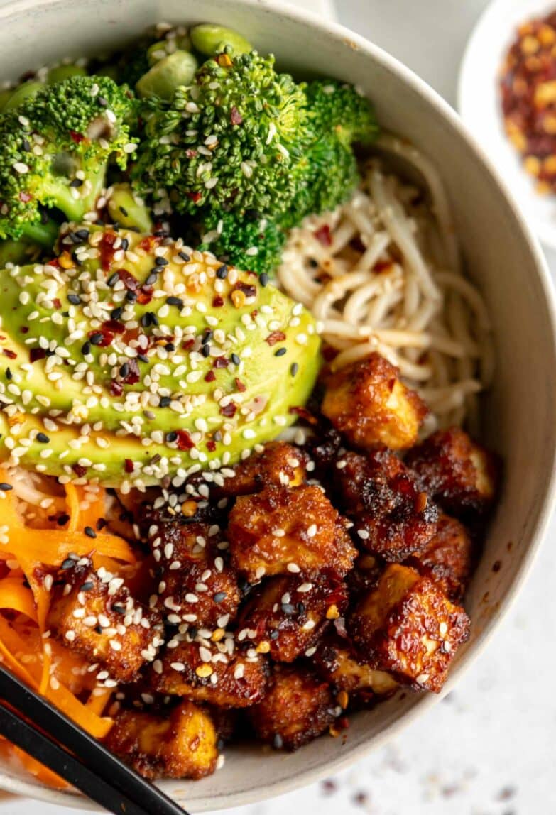 Asian fried tofu with avocado, veggies, and noodles.