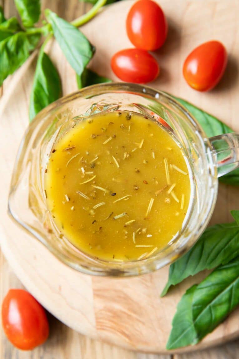 Top shot of homemade Italian Dressing Recipe with basil and tomatoes around it.