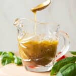 Spoon getting Italian Dressing out of jar.