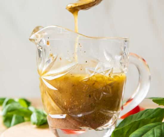 Spoon getting Italian Dressing out of jar.