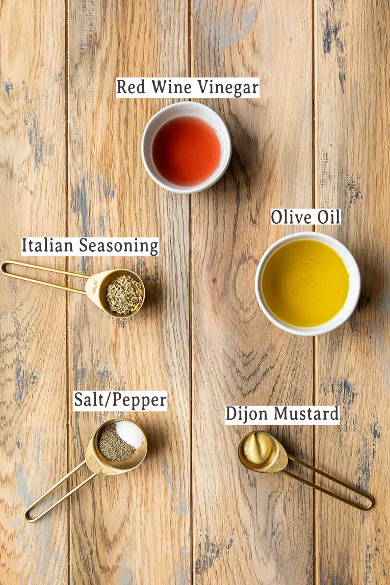 Ingredients for homemade Italian dressing recipe on a wood table.