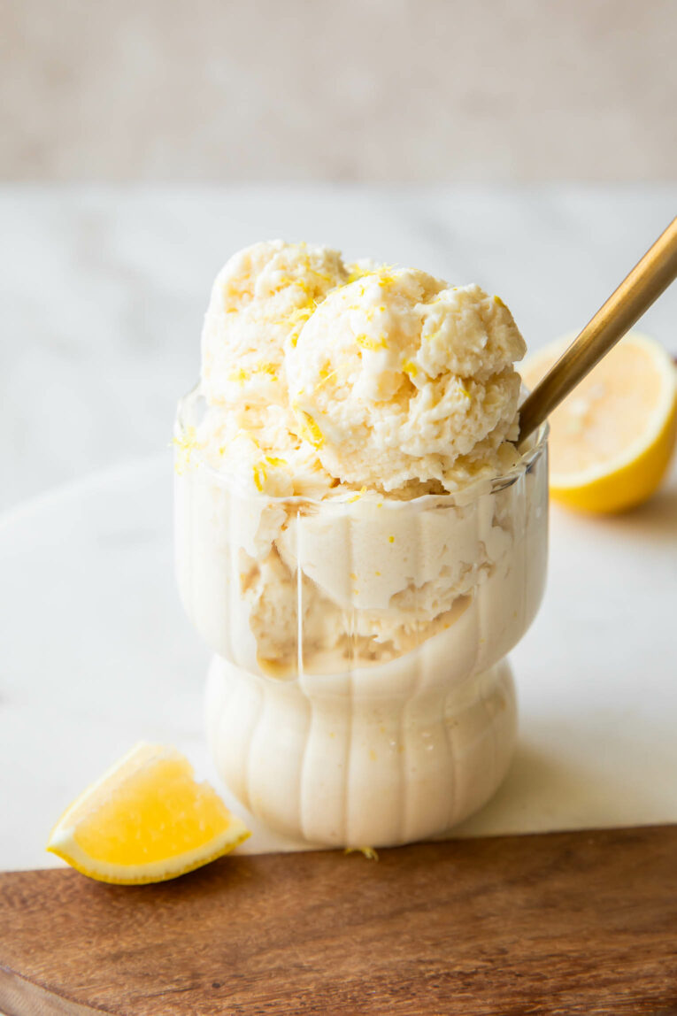 Angled photo of Lemon Ice Cream recipe in a glass with a spoon.