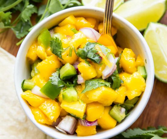 Styled Mango Salsa Recipe in a small bowl with a spoon.