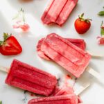 Strawberry Chia Seed Popsicles on a marble countertop.