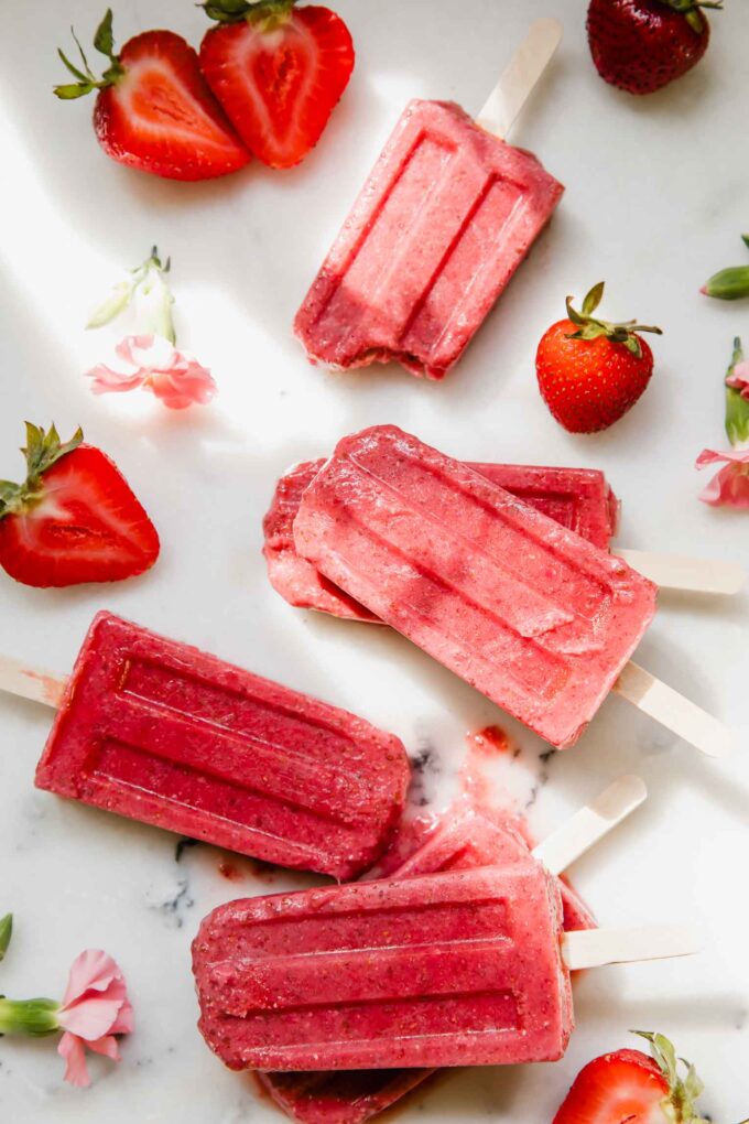 Strawberry Chia Seed Popsicles on a marble countertop.