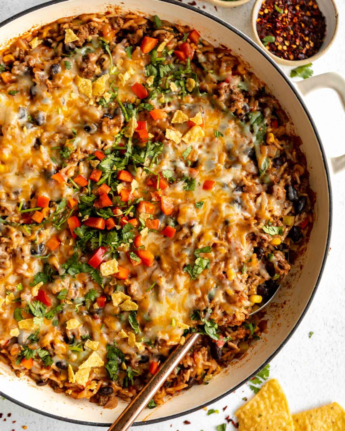 Close up top shot of Ground Beef & Rice Casserole in a skillet with a spoon.