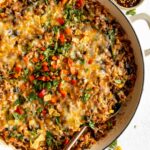 Close up top shot of Ground Beef & Rice Casserole in a skillet with a spoon.