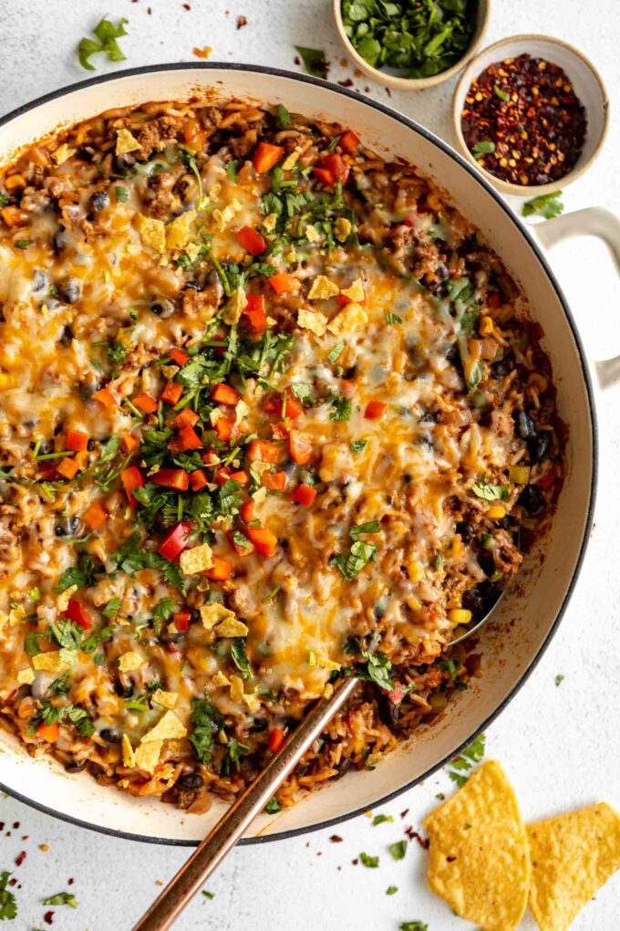 Close up top shot of Ground Beef & Rice Casserole in a skillet with a spoon.