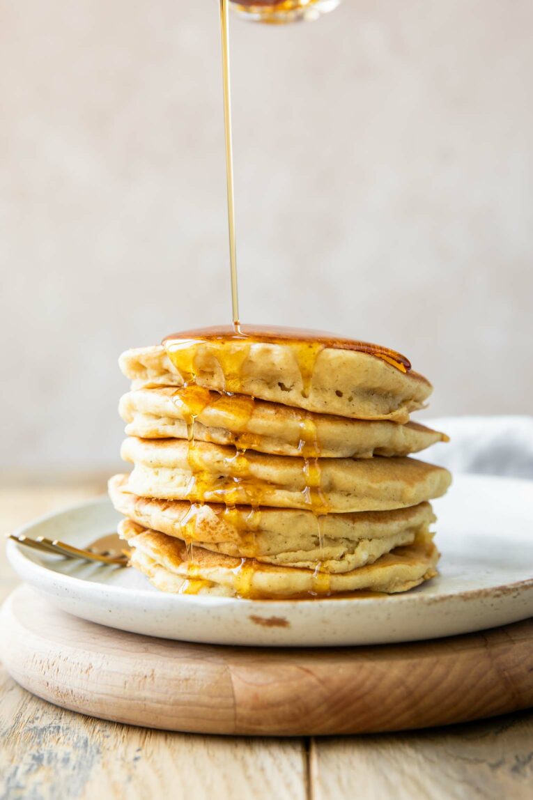 Stack of Gluten-Free Pancakes with syrup pouring over them.