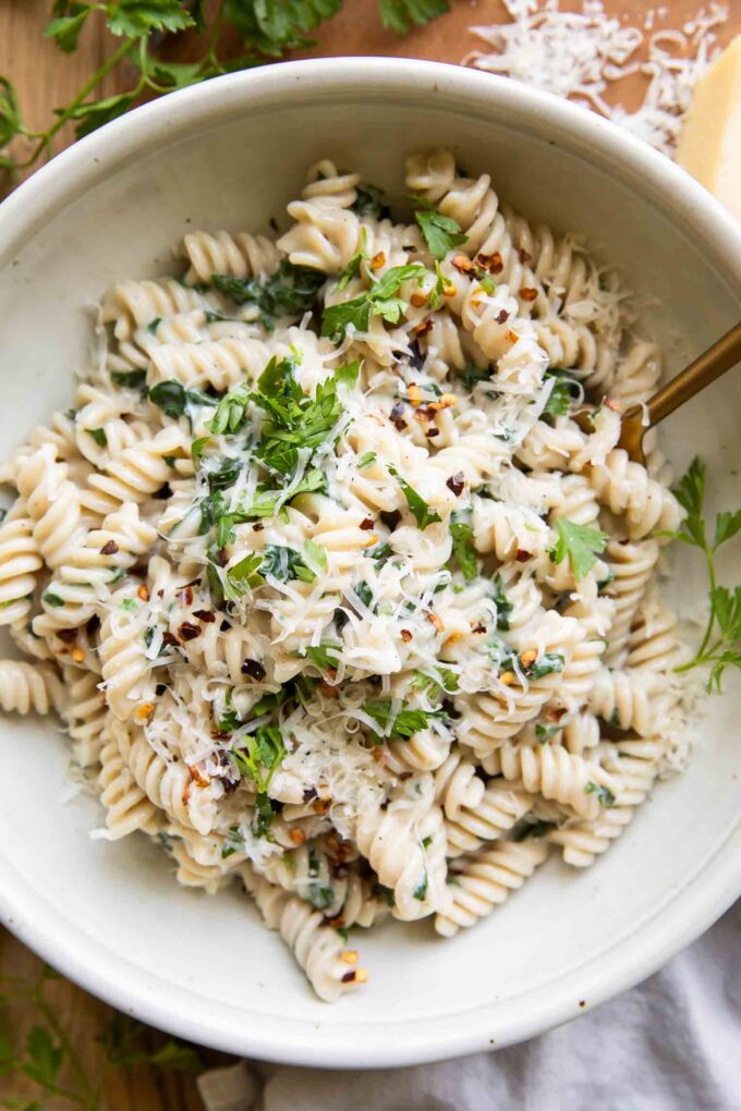 Protein Pasta Recipe in a bowl with spinach and parsley.
