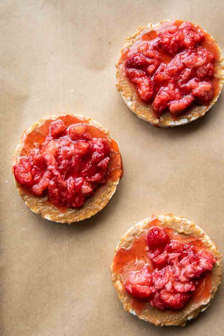 Mashed strawberries over cashew butter on a rice cake.