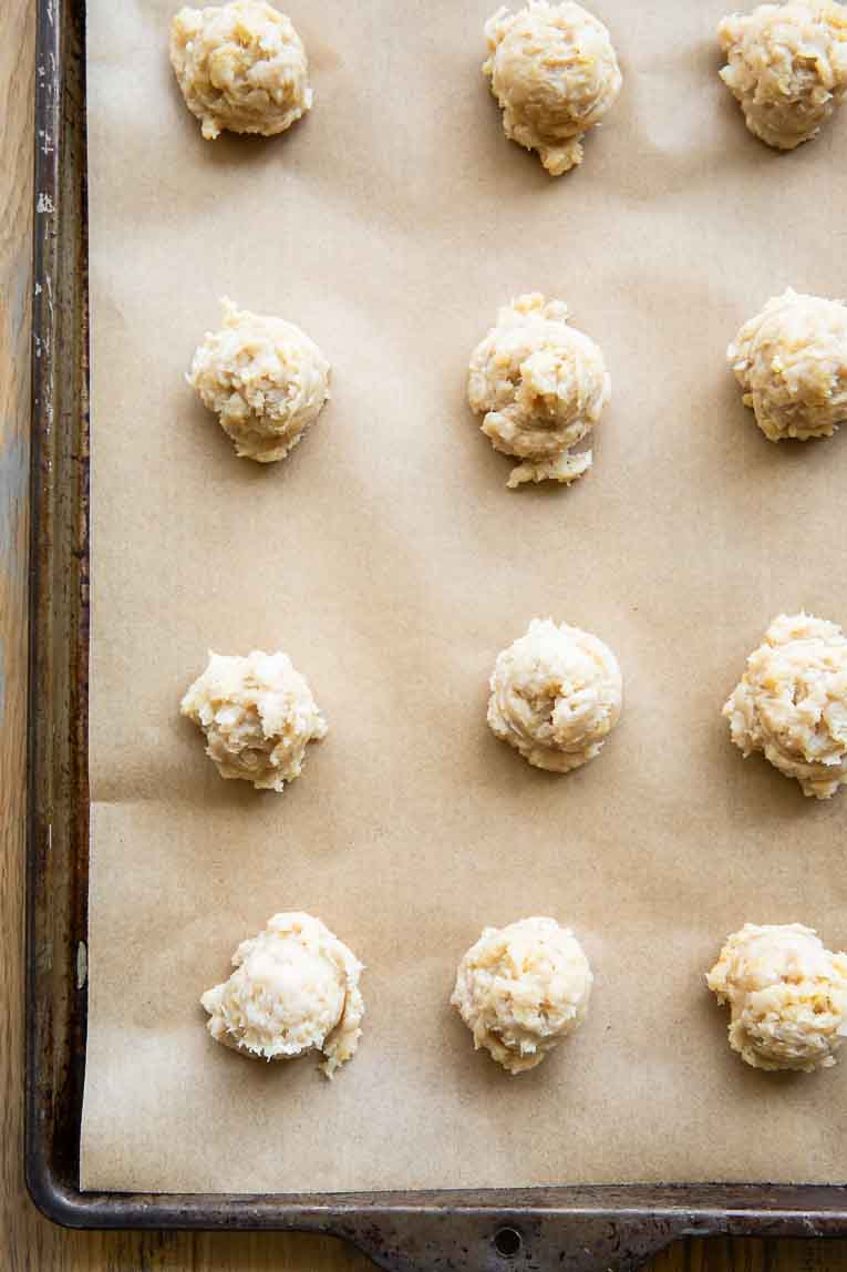 Chicken meatballs ready to bake on a baking sheet.