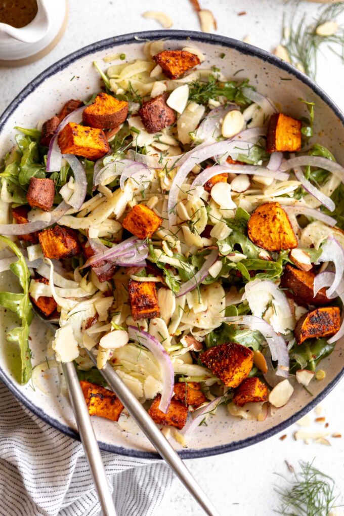 Close up of shaved fennel salad with sweet potatos on a plate.