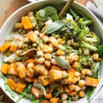 Roasted Chickpea Sweet Potatoes in a bowl with a fork and maple tahini sauce.
