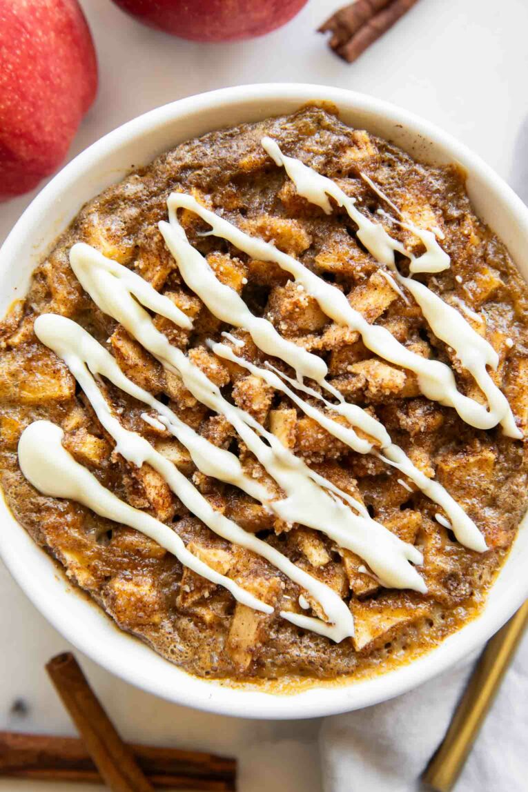 Baked oats with apples and white chocolate drizzle close up photo.