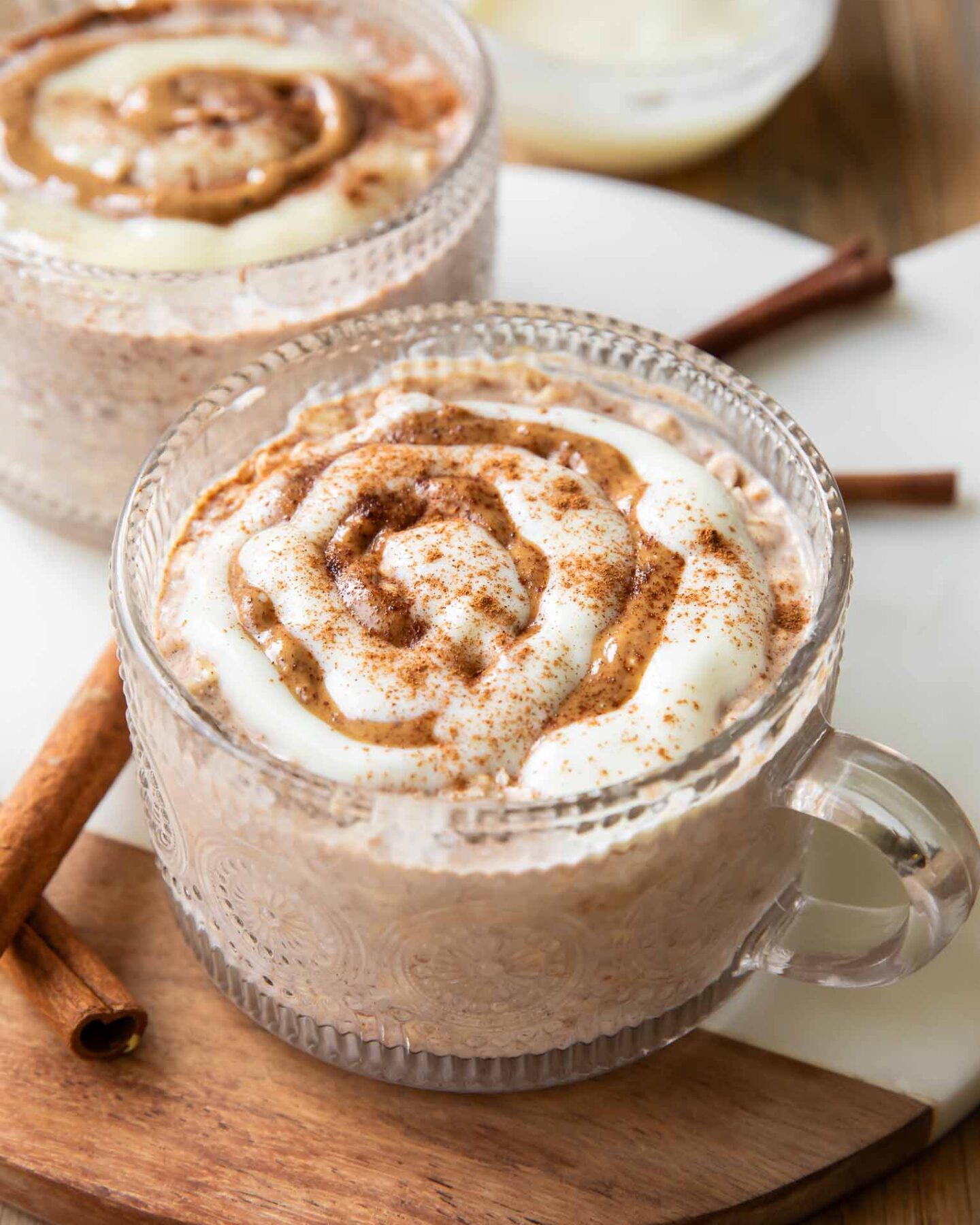 Cinnamon Roll Overnight Oats recipe in a mug jar with icing.
