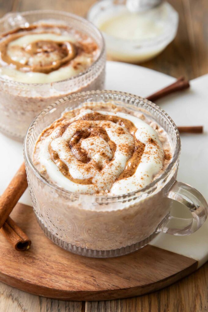 Cinnamon Roll Overnight Oats recipe in a mug jar with icing.