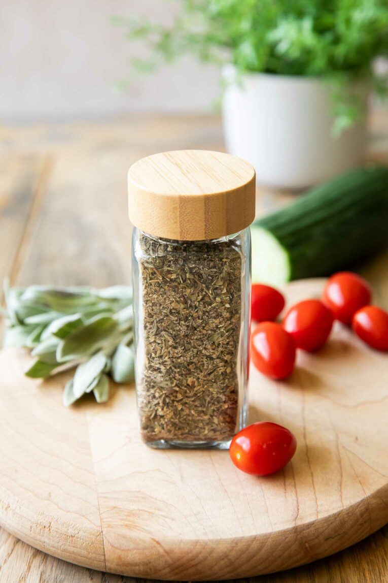 Angled photo of Greek Seasoning with cucumber and tomatoes.
