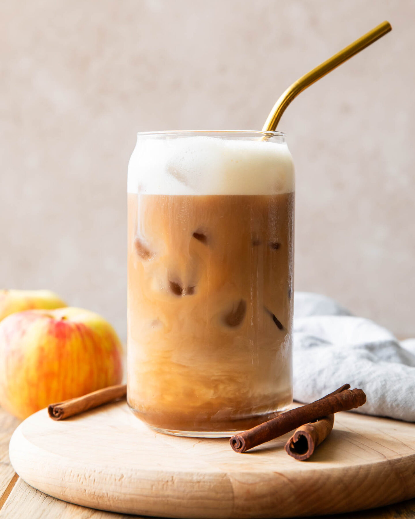 Iced Apple Crisp Cream Chai recipe in a glass with a straw.