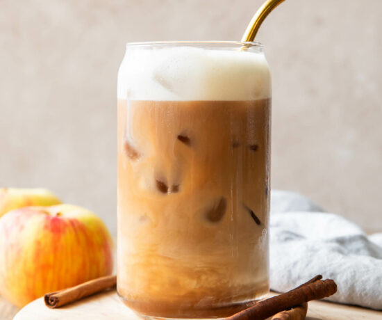 Iced Apple Crisp Cream Chai recipe in a glass with a straw.