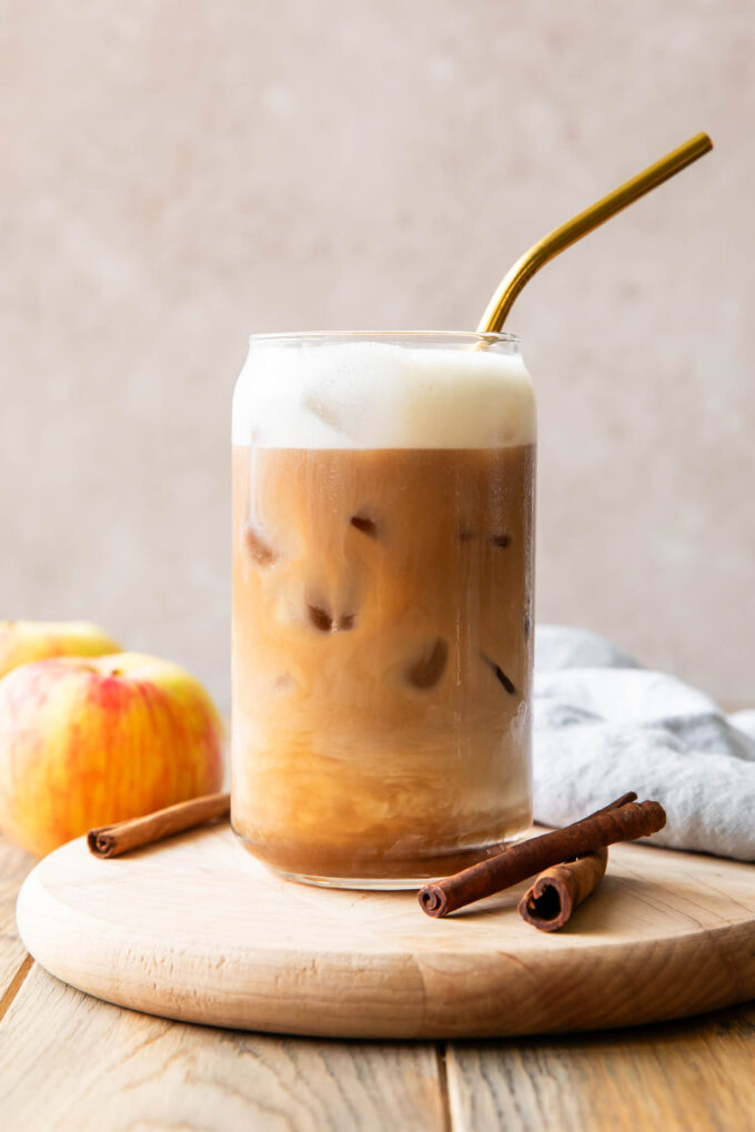 Iced Apple Crisp Cream Chai recipe in a glass with a straw.