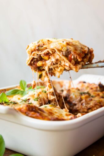 Across photo of healthy lasagna recipe slice being taken out of dish.