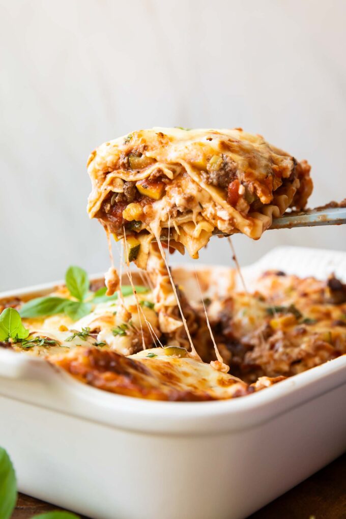 Across photo of healthy lasagna recipe slice being taken out of dish.