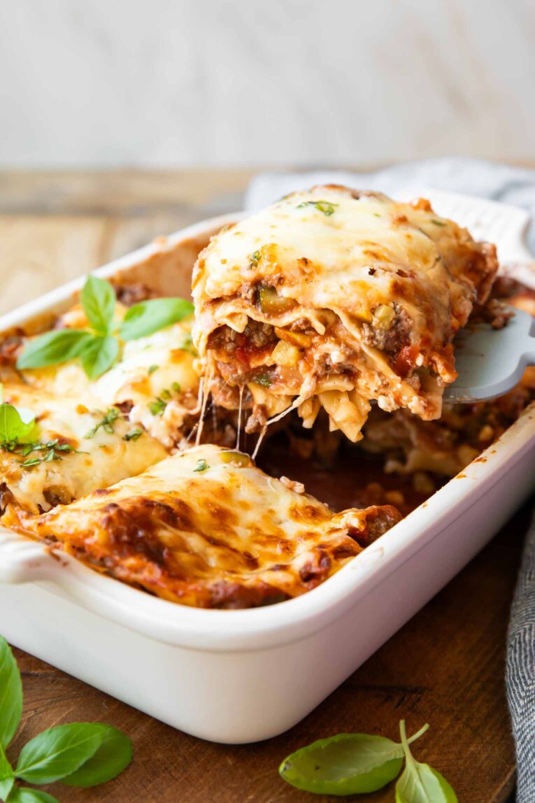Angled photo of healthy lasagna with a spoon taking out a slice.